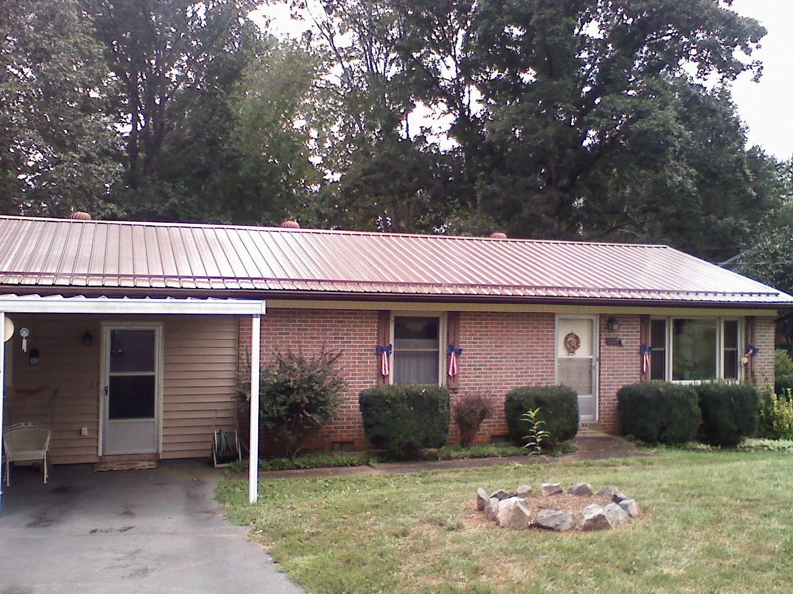 Bronze metal roof and carport on a brick ranch home — Roof Repair work by our crew in Riner